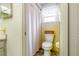 Cozy bathroom with floral wallpaper, a shower with a curtain, and a toilet with a basket on top at 28 W Highbanks Rd, Debary, FL 32713