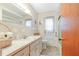 Clean bathroom with vintage vanity, mirror, decorative wallpaper, and shower at 28 W Highbanks Rd, Debary, FL 32713