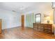 Bright bedroom with wood-look flooring, a ceiling fan, closet, and vintage dresser at 28 W Highbanks Rd, Debary, FL 32713