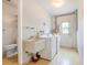 Functional laundry room featuring a utility sink, washer, dryer, and additional toilet at 28 W Highbanks Rd, Debary, FL 32713