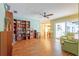 Spacious living room with hardwood floors, ceiling fan, bookshelf and access to the patio at 28 W Highbanks Rd, Debary, FL 32713
