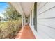 Covered porch with seating offering an inviting outdoor space with white pillars and green shutters at 28 W Highbanks Rd, Debary, FL 32713