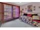 Bedroom with floral bedding, side table, and large window with pink vertical blinds at 29 Ramblewood Trl, Deland, FL 32724