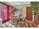 Charming dining area with a round wooden table, upholstered chairs, and a decorative mirror, enhanced by natural light at 29 Ramblewood Trl, Deland, FL 32724