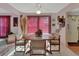 Bright dining room with an octagonal wooden table, comfortable chairs, and sliding glass doors with vertical blinds at 29 Ramblewood Trl, Deland, FL 32724