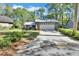Quaint one-story home with a wide driveway, a two-car garage, and a well-maintained lawn with mature trees at 29 Ramblewood Trl, Deland, FL 32724