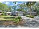 The front exterior of the home with a beautiful lawn, and long driveway leading to a two-car garage at 29 Ramblewood Trl, Deland, FL 32724