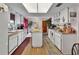 Cozy kitchen featuring white cabinetry, appliances, and a center island, complemented by warm wood floors and natural light at 29 Ramblewood Trl, Deland, FL 32724