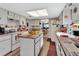 Bright kitchen featuring ample counter space, white appliances, and an open layout leading to the dining area at 29 Ramblewood Trl, Deland, FL 32724