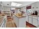 Functional kitchen with white cabinets, an island, and a view of the adjacent dining area at 29 Ramblewood Trl, Deland, FL 32724