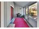 Cozy screened-in porch area with a grill, red rug, and view of the outdoor space at 29 Ramblewood Trl, Deland, FL 32724