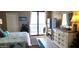 Bright bedroom with balcony access, a dresser, and decorative ocean-themed accents at 3003 S Atlantic Ave # 19B4, Daytona Beach, FL 32118
