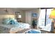 Cozy bedroom featuring a queen bed with beach-themed decor and a sliding glass door to a balcony at 3003 S Atlantic Ave # 19B4, Daytona Beach, FL 32118