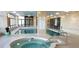 Indoor community pool and hot tub area with tile surround, well lit, and large windows at 3003 S Atlantic Ave # 19B4, Daytona Beach, FL 32118