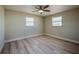 Bedroom with light hardwood floors, a ceiling fan, and two bright windows at 302 Lafayette St, Port Orange, FL 32127