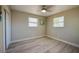 Bedroom with light hardwood floors, a ceiling fan, closet and two bright windows at 302 Lafayette St, Port Orange, FL 32127