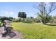 Large grassy backyard showing tropical landscaping, trees, and grilling station at 307 Heron Point Way, Deland, FL 32724