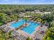 Aerial view of a large community pool with pergolas, lounge chairs, and lush landscaping, perfect for relaxation at 307 Heron Point Way, Deland, FL 32724