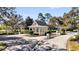 Charming guard house at the entrance to a gated community with lush trees and landscaping at 307 Heron Point Way, Deland, FL 32724