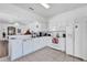 Bright kitchen featuring white cabinetry, appliances, and tile flooring, with a view into the adjacent living area at 307 Heron Point Way, Deland, FL 32724