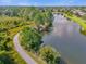 Scenic aerial view of a tranquil pond with a walking path and lush foliage, offering a peaceful retreat at 307 Heron Point Way, Deland, FL 32724