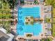 Aerial view of a large community swimming pool with palm trees, lounge chairs, and manicured landscaping at 307 Heron Point Way, Deland, FL 32724