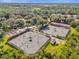 Aerial view of well-maintained tennis courts surrounded by lush greenery in a serene community setting at 307 Heron Point Way, Deland, FL 32724