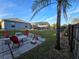 Spacious backyard featuring a fire pit, screened pool and lush greenery at 3209 S Dorchester Dr, Deltona, FL 32738