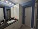 Bathroom featuring a granite countertop vanity, white cabinets, and a tiled shower at 3209 S Dorchester Dr, Deltona, FL 32738