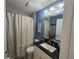 Well-lit bathroom with a granite countertop vanity, tile shower, and neutral decor at 3209 S Dorchester Dr, Deltona, FL 32738