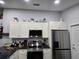 Modern kitchen with stainless steel appliances, granite countertops, and white cabinetry with decor on top at 3209 S Dorchester Dr, Deltona, FL 32738