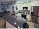 Beautiful kitchen island with dark countertops, stainless steel appliances and modern white cabinets at 3209 S Dorchester Dr, Deltona, FL 32738