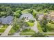 Aerial view of home with lush landscaping, a large driveway, and a golf course in the background at 369 Caddie Dr, Debary, FL 32713