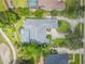 An aerial view of a landscaped home with screened in pool and a golf course nearby at 369 Caddie Dr, Debary, FL 32713