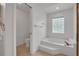 Bright, tiled bathroom featuring a soaking tub with glass block window, a toilet, and a separate shower area at 369 Caddie Dr, Debary, FL 32713