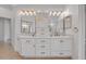 Bathroom featuring a long dual sink vanity with white cabinets, gold fixtures and mirrors, and tiled floors at 369 Caddie Dr, Debary, FL 32713