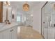 Bright bathroom featuring a chandelier, dual vanities, tiled floors, and a glass-enclosed shower and soaking tub at 369 Caddie Dr, Debary, FL 32713