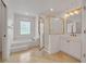 Tiled bathroom featuring a soaking tub, glass block window, and a gold framed glass enclosed shower at 369 Caddie Dr, Debary, FL 32713