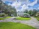Landscaped front yard featuring a circular driveway leading to a well-maintained one story home with mature trees at 369 Caddie Dr, Debary, FL 32713