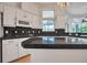 Kitchen with black countertops, white cabinets, tile backsplash and abundant lighting at 369 Caddie Dr, Debary, FL 32713