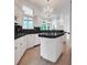 Bright kitchen featuring white cabinetry, black countertops, and a decorative chandelier at 369 Caddie Dr, Debary, FL 32713