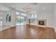 Living room with hardwood floors, fireplace, chandelier and glass doors to pool at 369 Caddie Dr, Debary, FL 32713