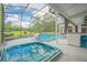 Screen enclosed pool with golf course view, hot tub, and outdoor living space at 369 Caddie Dr, Debary, FL 32713