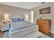 Well-lit bedroom featuring a bed with blue accents, side tables, and a wooden dresser at 37 Fairway Ct # C, Deland, FL 32724