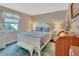 Cozy bedroom with a white bed, a bench, light blue accents, and a window offering natural light at 37 Fairway Ct # C, Deland, FL 32724