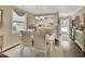 Bright dining area with white table, chairs, and chandelier, flowing into a white kitchen at 37 Fairway Ct # C, Deland, FL 32724