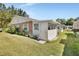 Charming home exterior showcasing brick accents, a well-maintained lawn, and an enclosed porch at 37 Fairway Ct # C, Deland, FL 32724