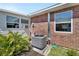 Backyard of home with an AC unit, brick accents, a green lawn, and lush greenery at 37 Fairway Ct # C, Deland, FL 32724