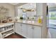 Bright kitchen featuring white cabinets, modern appliances, and a convenient breakfast bar at 37 Fairway Ct # C, Deland, FL 32724