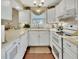 Bright kitchen featuring white cabinetry, light countertops, stainless steel appliances, and pendant lighting at 37 Fairway Ct # C, Deland, FL 32724